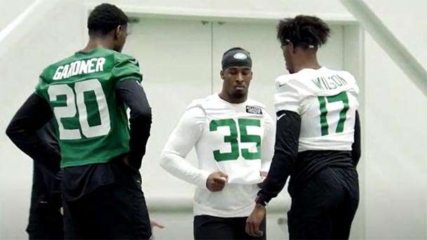 Breece Hall talks with two of his Jets football teammates.