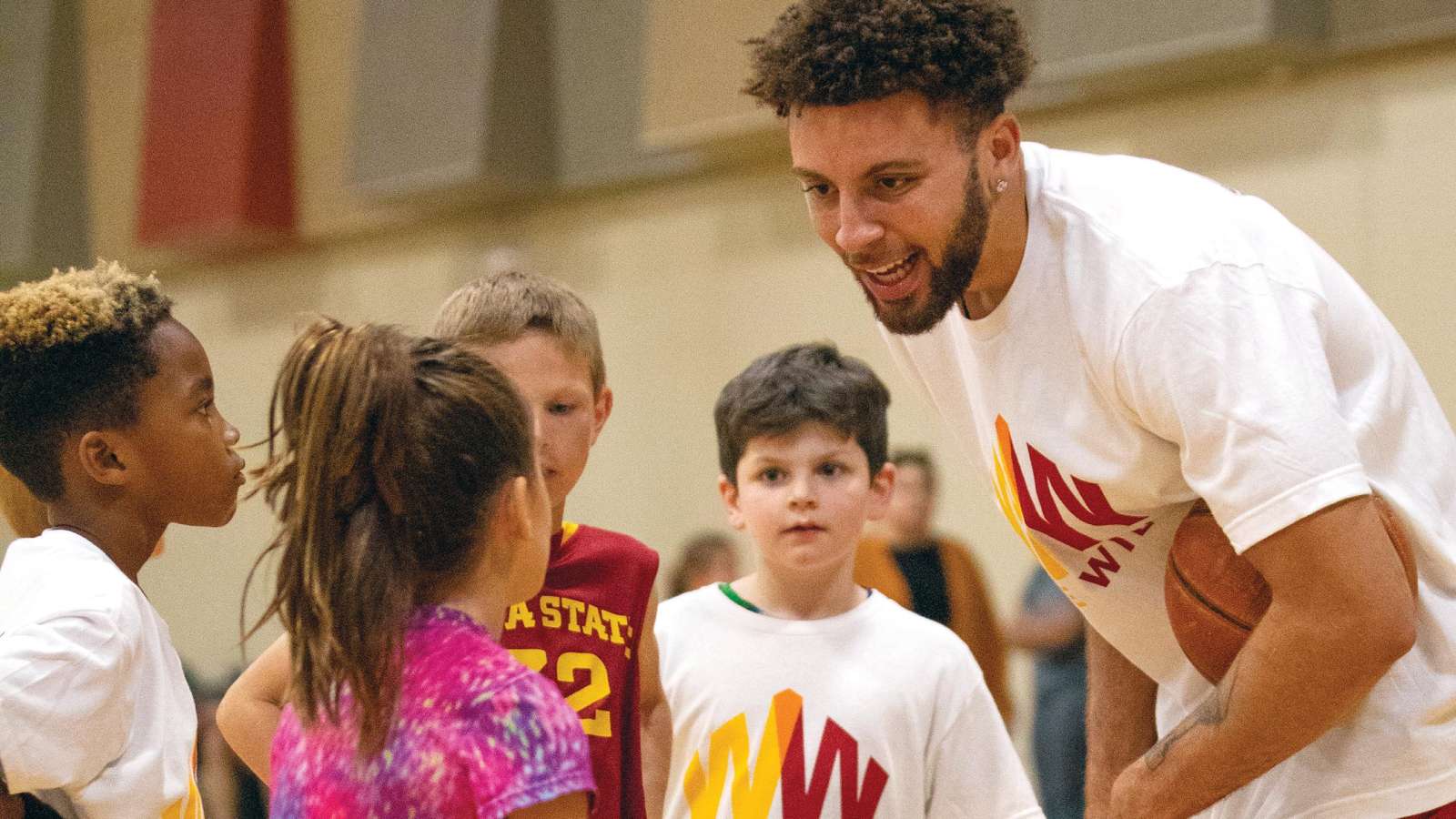 Gabe Kalscheur working with kids on their basketball skills.