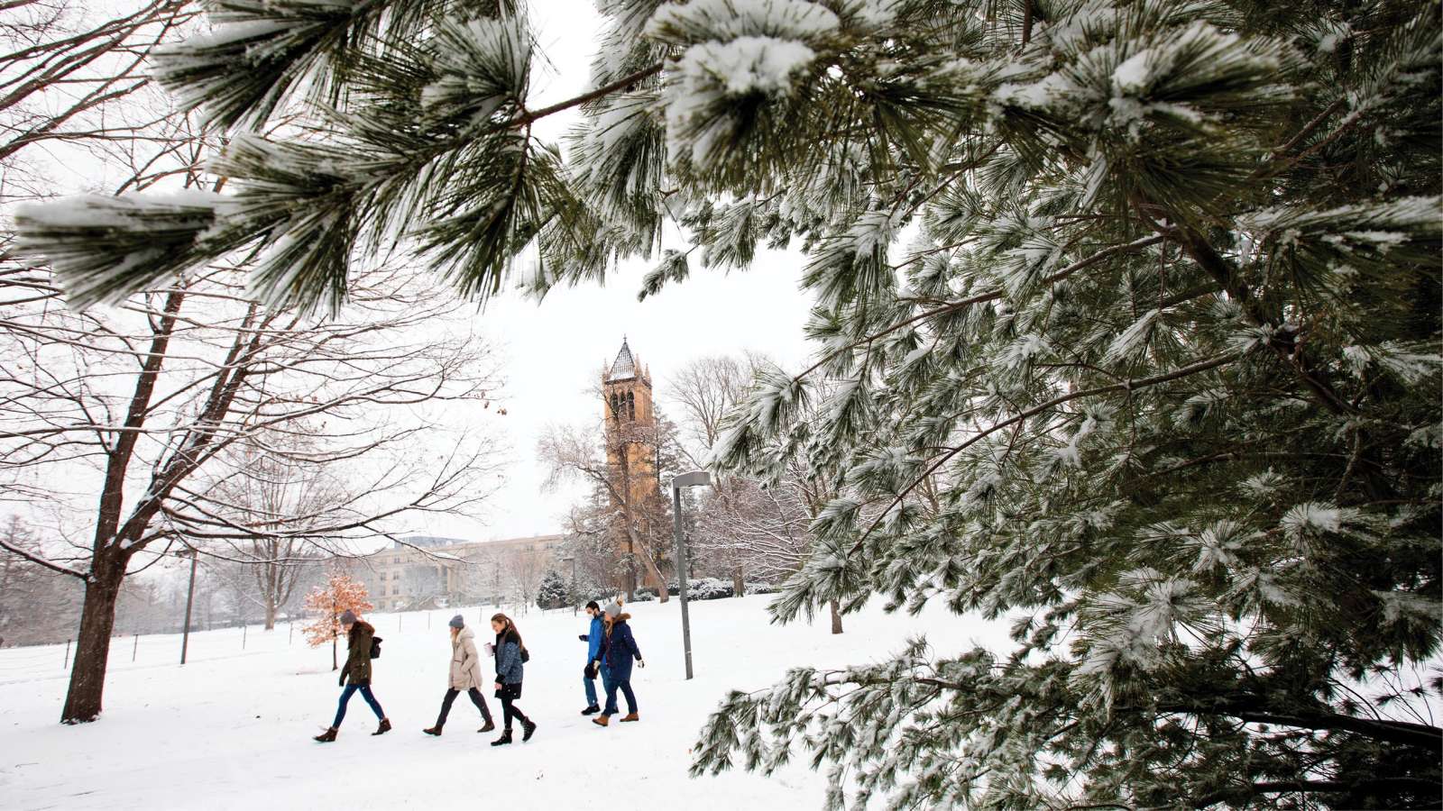 Snowy view of central campus with bundled up pedestrians.