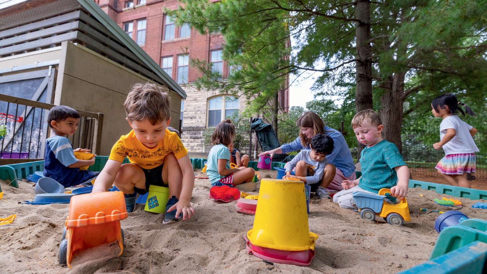 Young students play in a sandbox with teacher Katie Moore. Students at ISU’s Child Development Laboratory School are encouraged to learn through play.